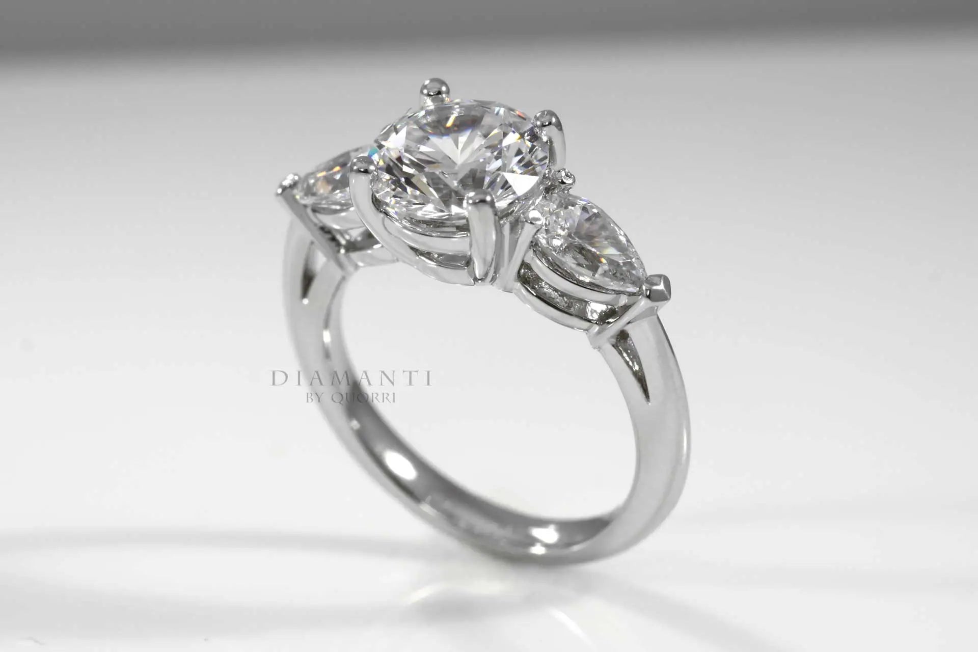 three stone 2ct round and pear accented lab grown diamond engagement ring