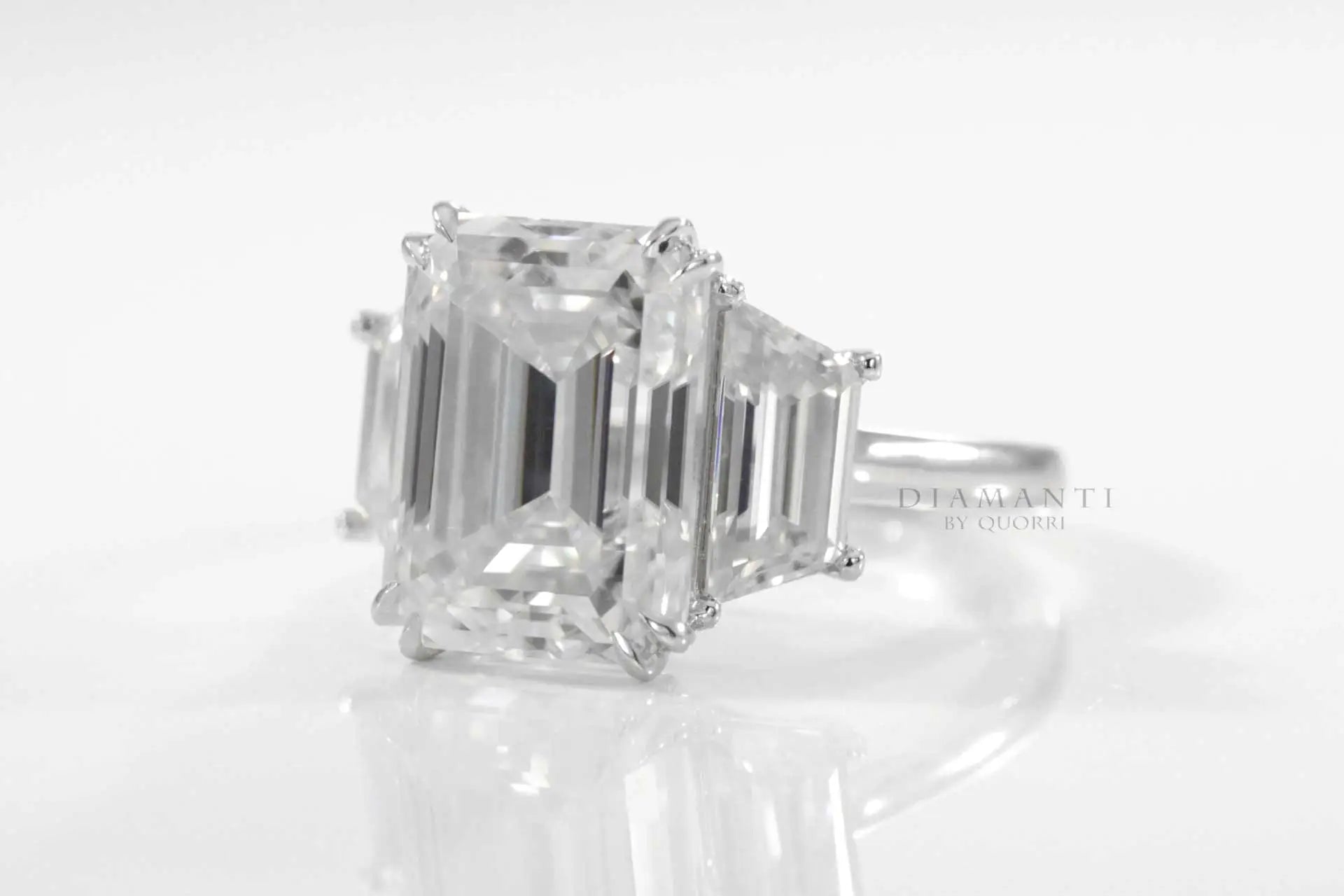 dual claw emerald and trapezoid three stone lab diamond engagement ring quorri