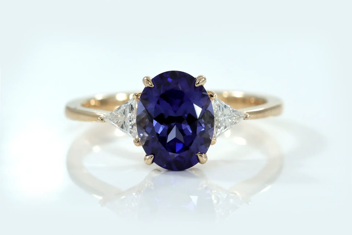 designer three stone 14k yellow gold claw prong 2 carat oval lab grown tanzanite with lab diamond triangle sides engagement ring Quorri