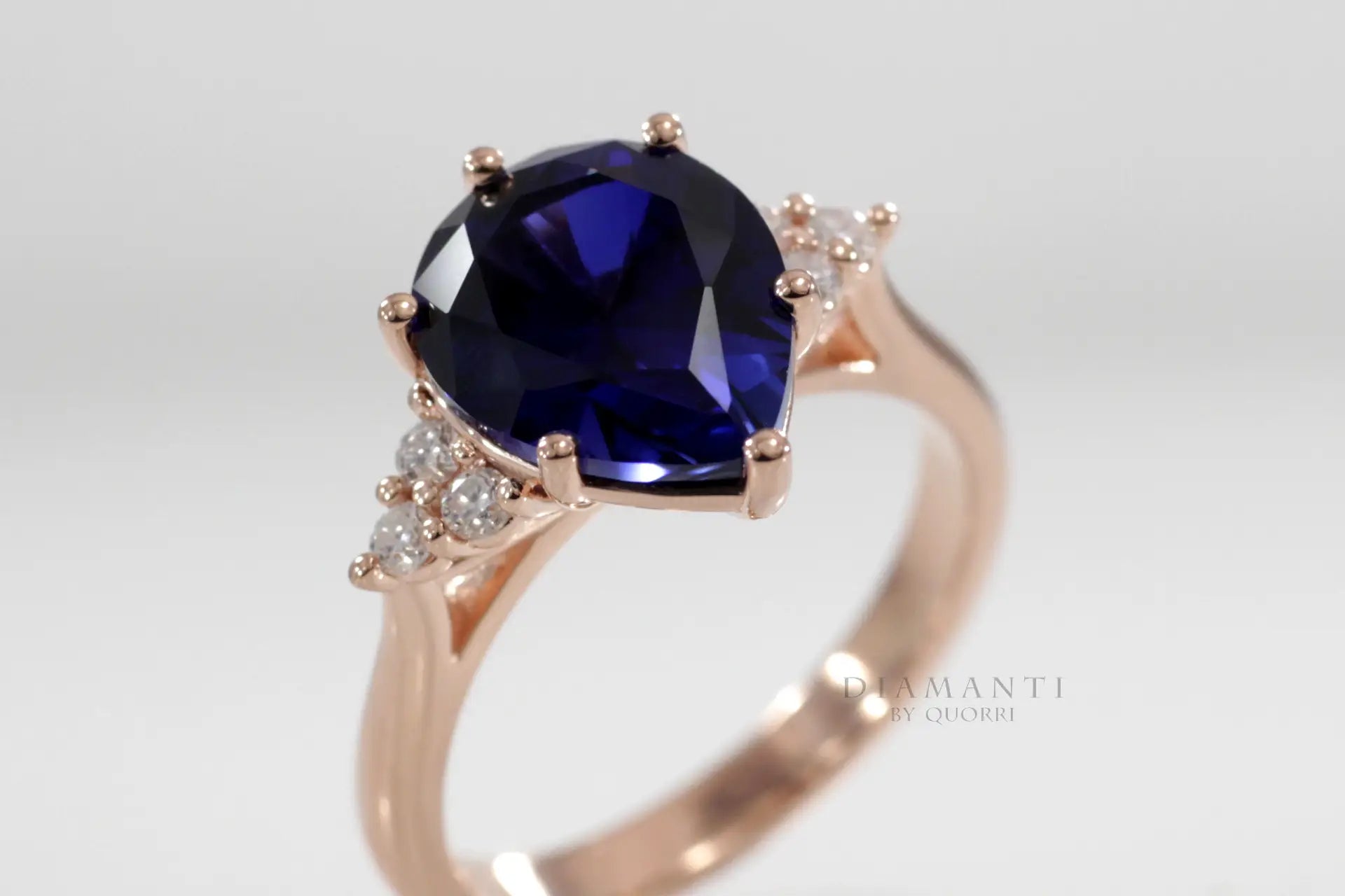 designer 6 prong 2.5 carat pear cut lab grown blue sapphire engagement ring in rose gold with round accents  Quorri Canada