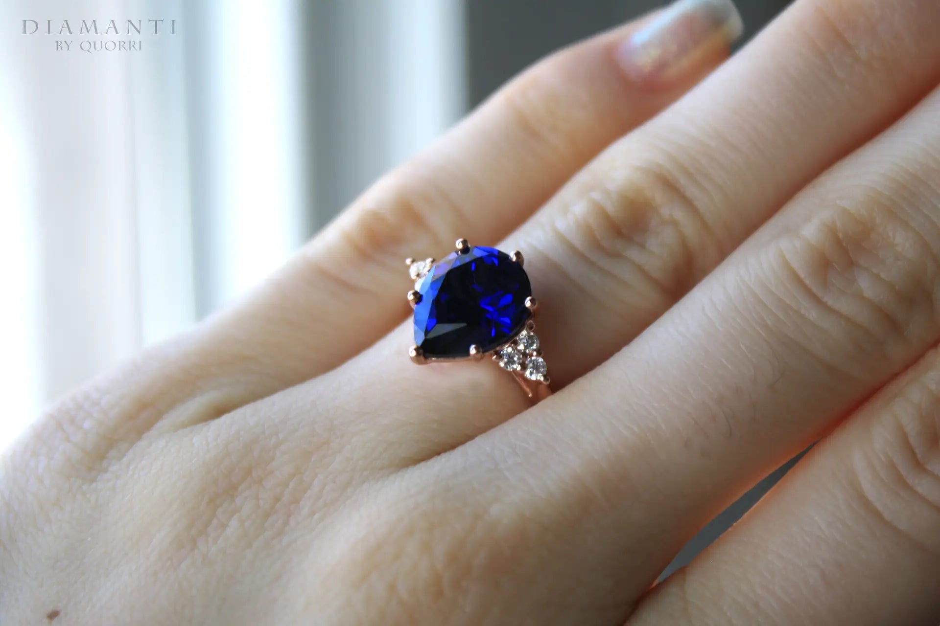 affordable rose gold  2.75 carat pear cut lab grown blue sapphire 6 prong engagement ring with diamond accents Quorri Canada