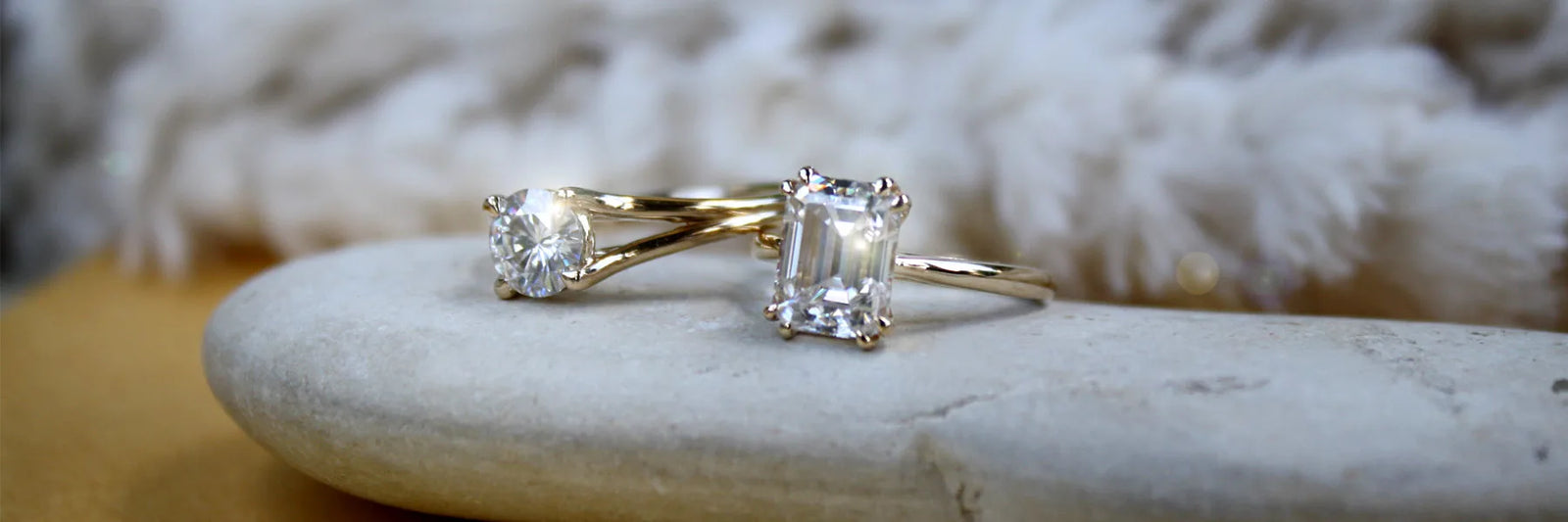 round lab diamond solitaire and emerald lab diamond solitaire ring on natural rock
