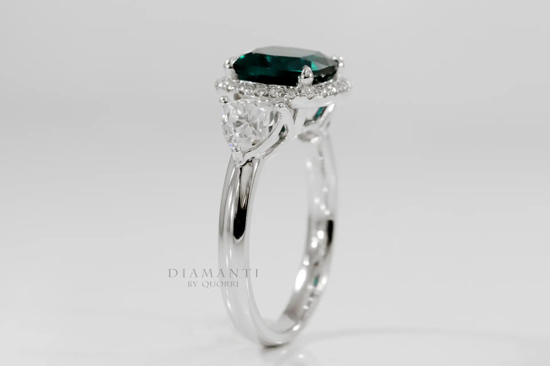 18k white gold designer three stone green emerald and trillion halo diamond engagement ring Canada