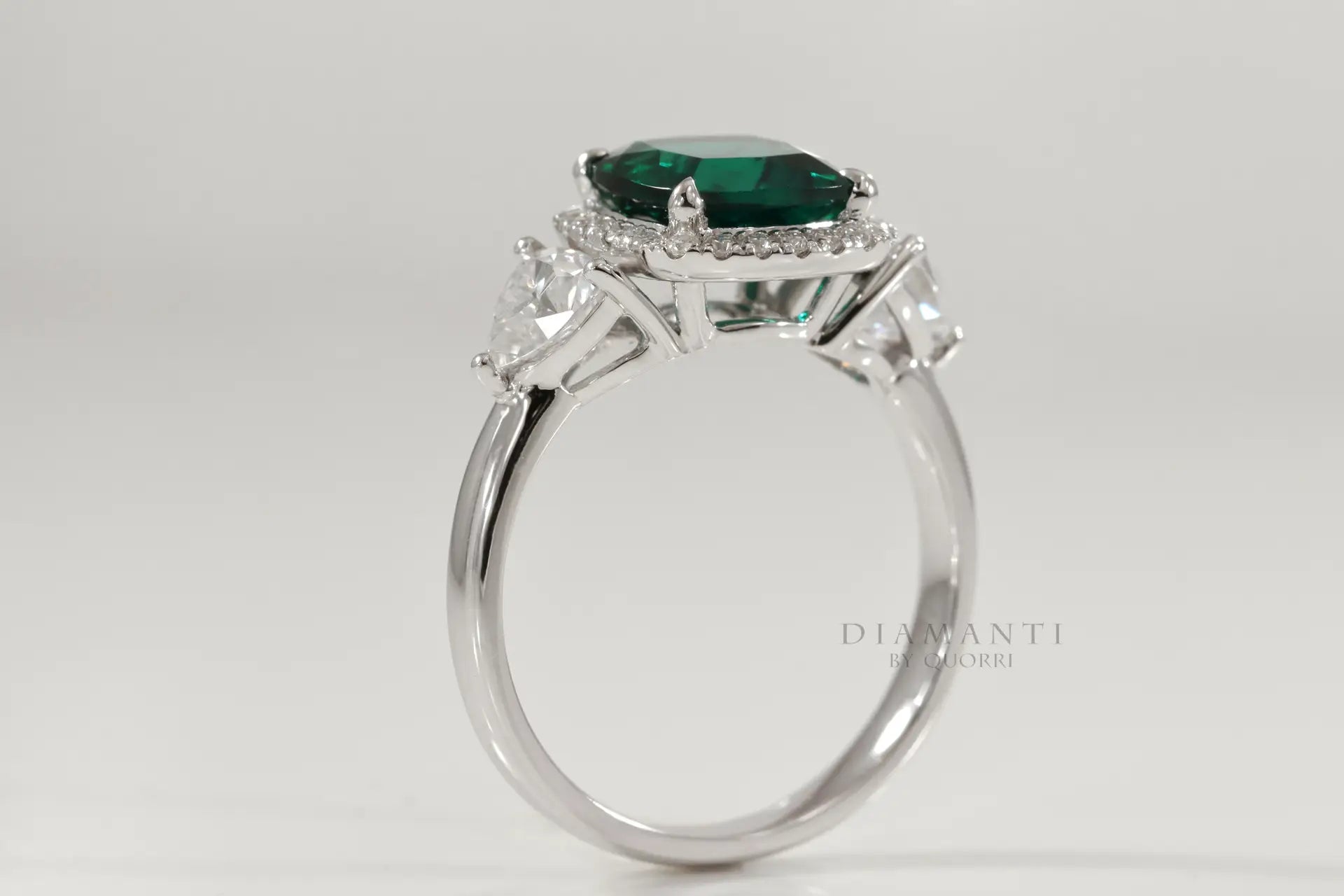 affordable designer platinum three stone green emerald and trillion halo diamond engagement ring Canada
