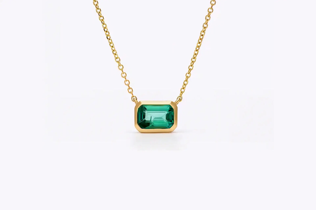 designer yellow gold bezel set 1.50 carat lab grown green emerald pendant with built in chain at Quorri