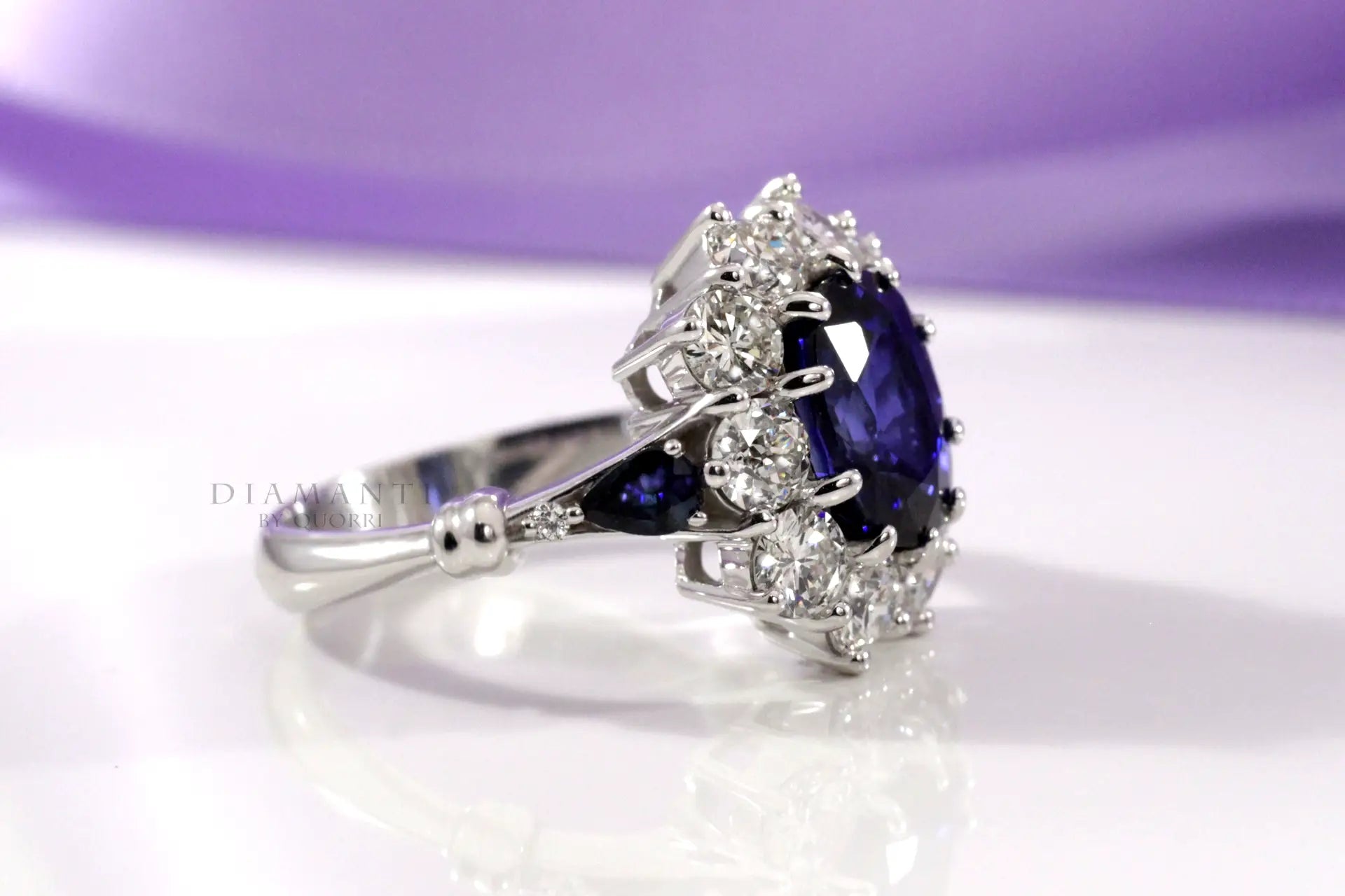 18k white gold designer diamond halo with oval blue lab grown sapphire center and sides engagement ring Quorri