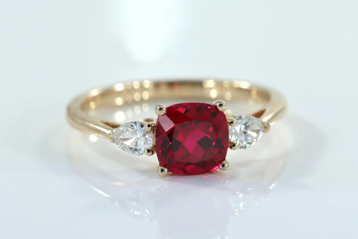designer 14k yellow gold three stone 1.50 carat lab grown cushion ruby and .50ct.tw pear lab diamond engagement ring Quorri