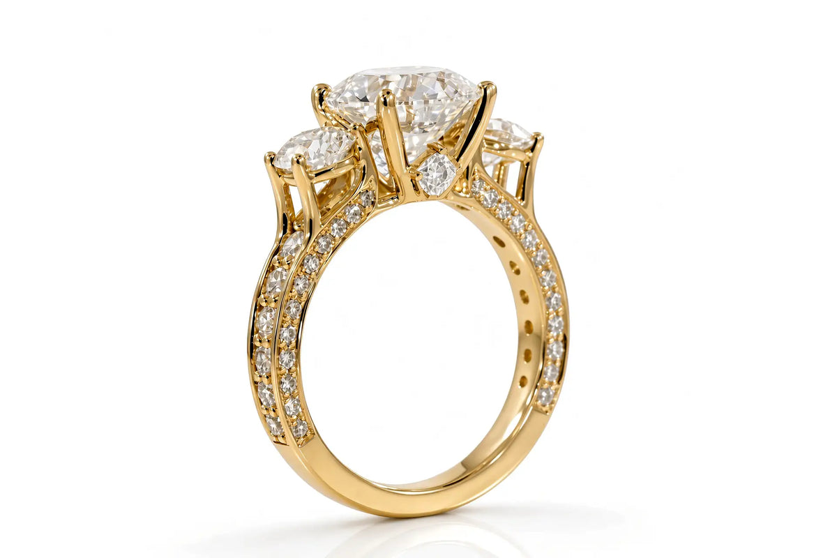 Yellow gold three-stone anniversary ring with round brilliant diamond, pavé shoulders, and princess-cut diamond accent