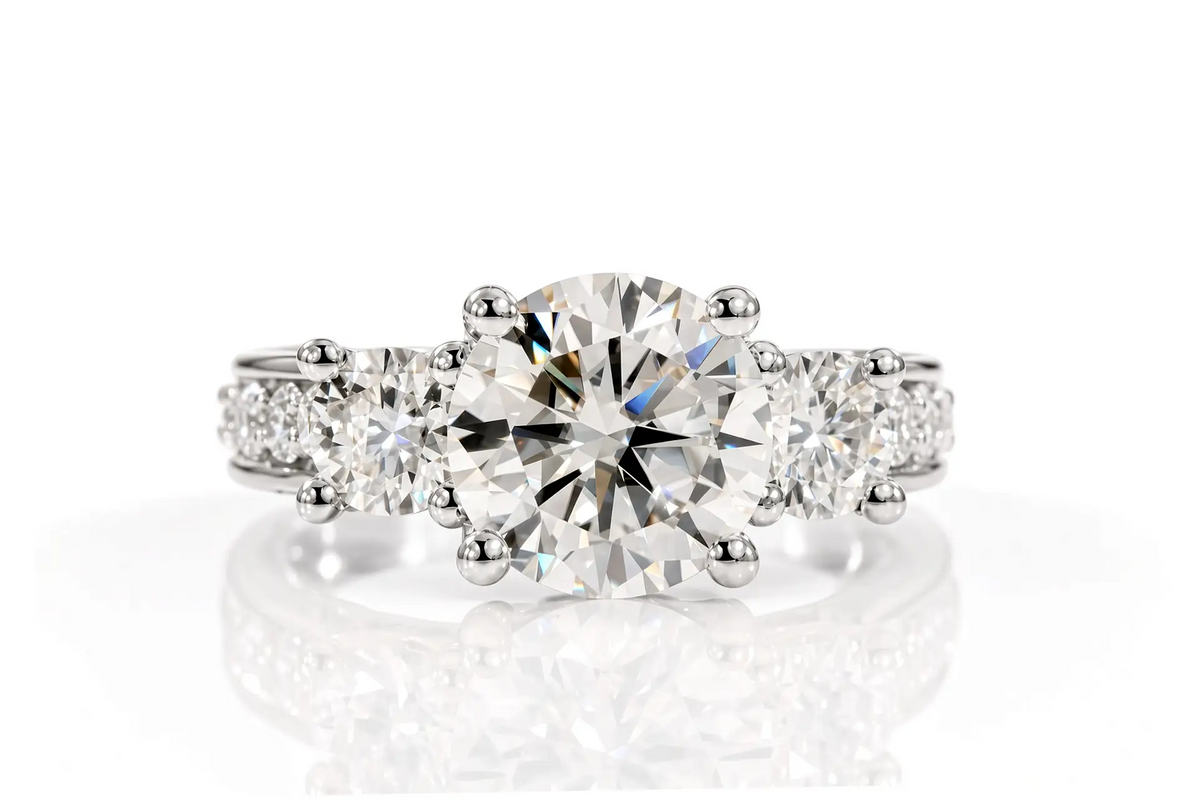 White gold three-stone engagement ring with round brilliant diamond, pavé shoulders, and princess-cut sapphire accent
