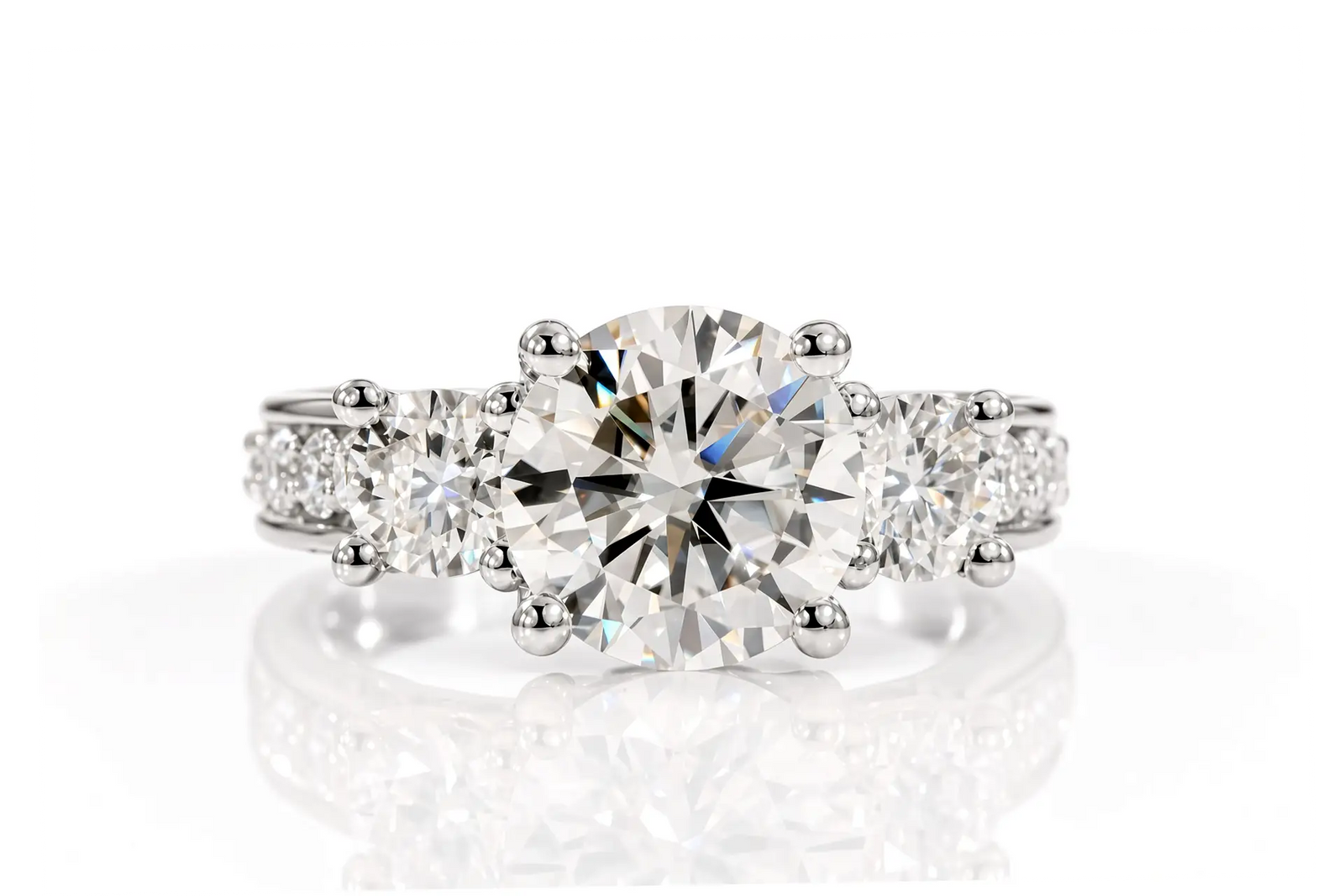 Three-stone diamond anniversary ring with a round-cut center stone and smaller diamonds along the shoulders features a euro bottom and blue sapphire princess accent