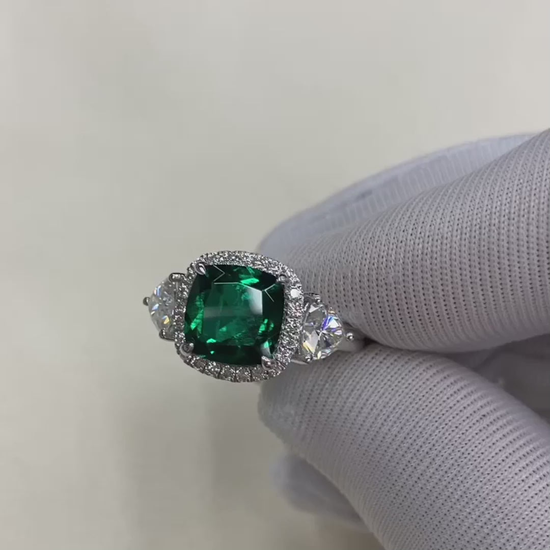 18k white gold cushion cut designer three stone green emerald and trillion halo diamond engagement ring Quorri Canada