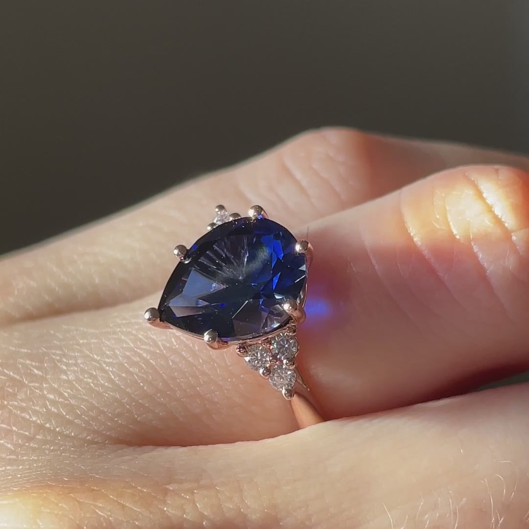 diamond accented cluster rose gold 6 prong 3.5 carat pear cut lab grown blue sapphire engagement ring at Quorri Canada